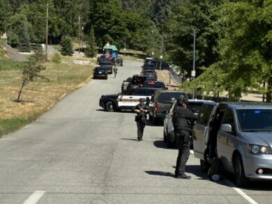 Aftermath of the Coeur d'Alene shooting incident on Canfield Mountain, showing emergency response vehicles.